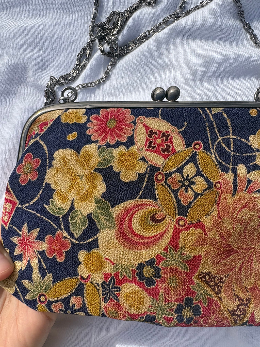 Clutch con motivos florales y cadena