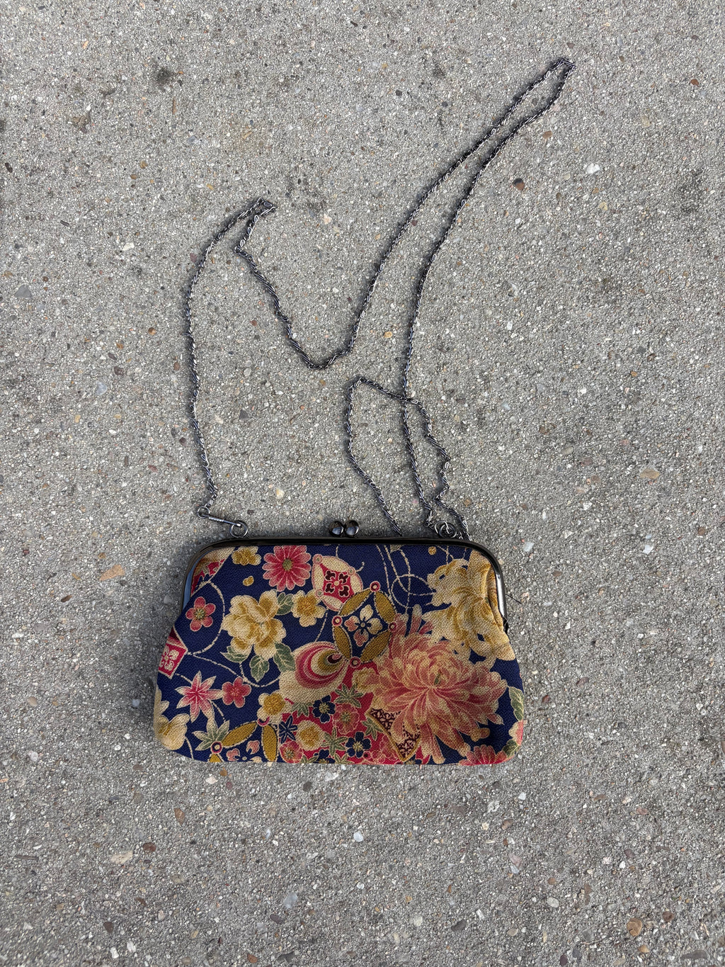 Clutch con motivos florales y cadena