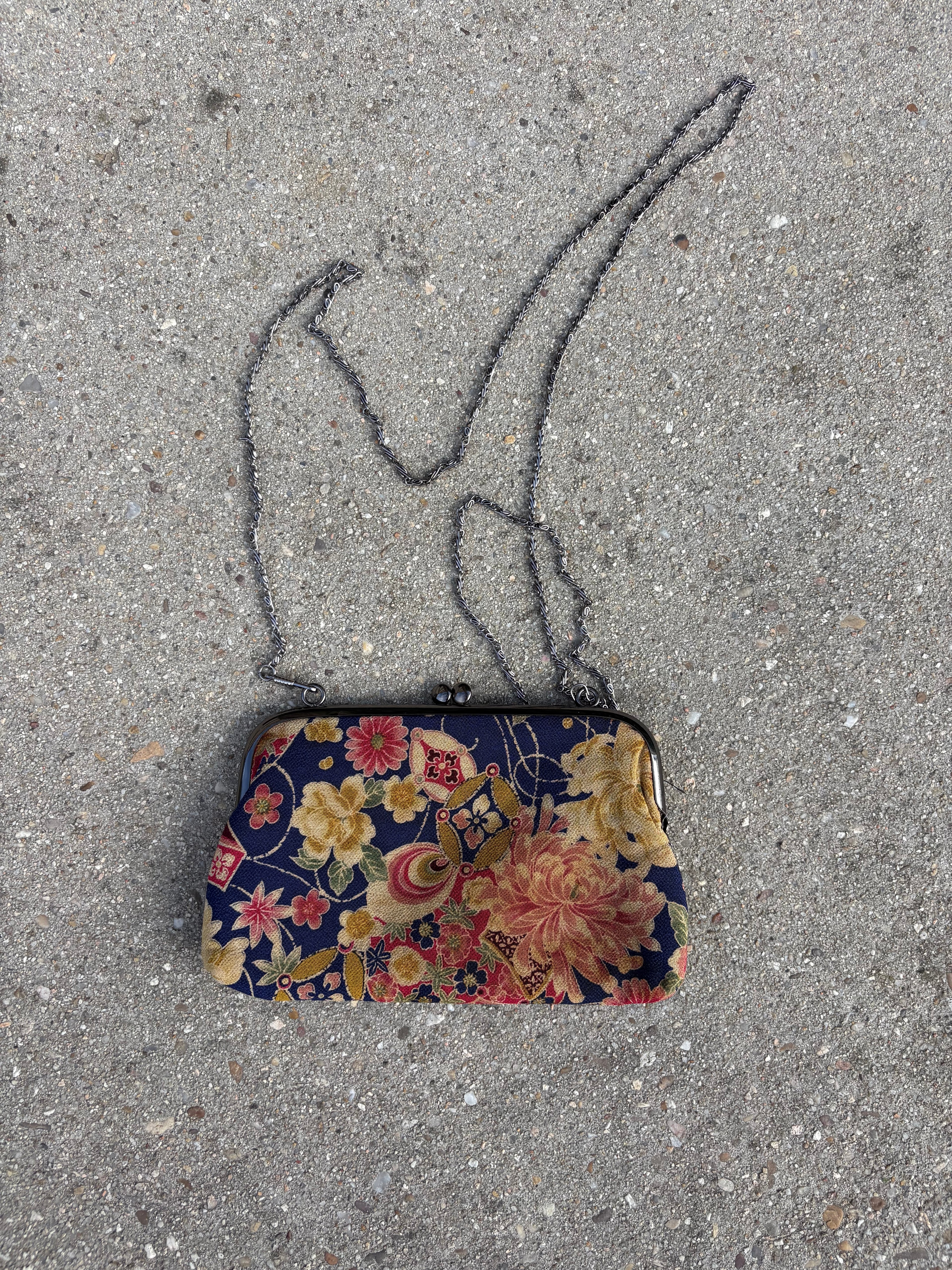 Clutch con motivos florales y cadena