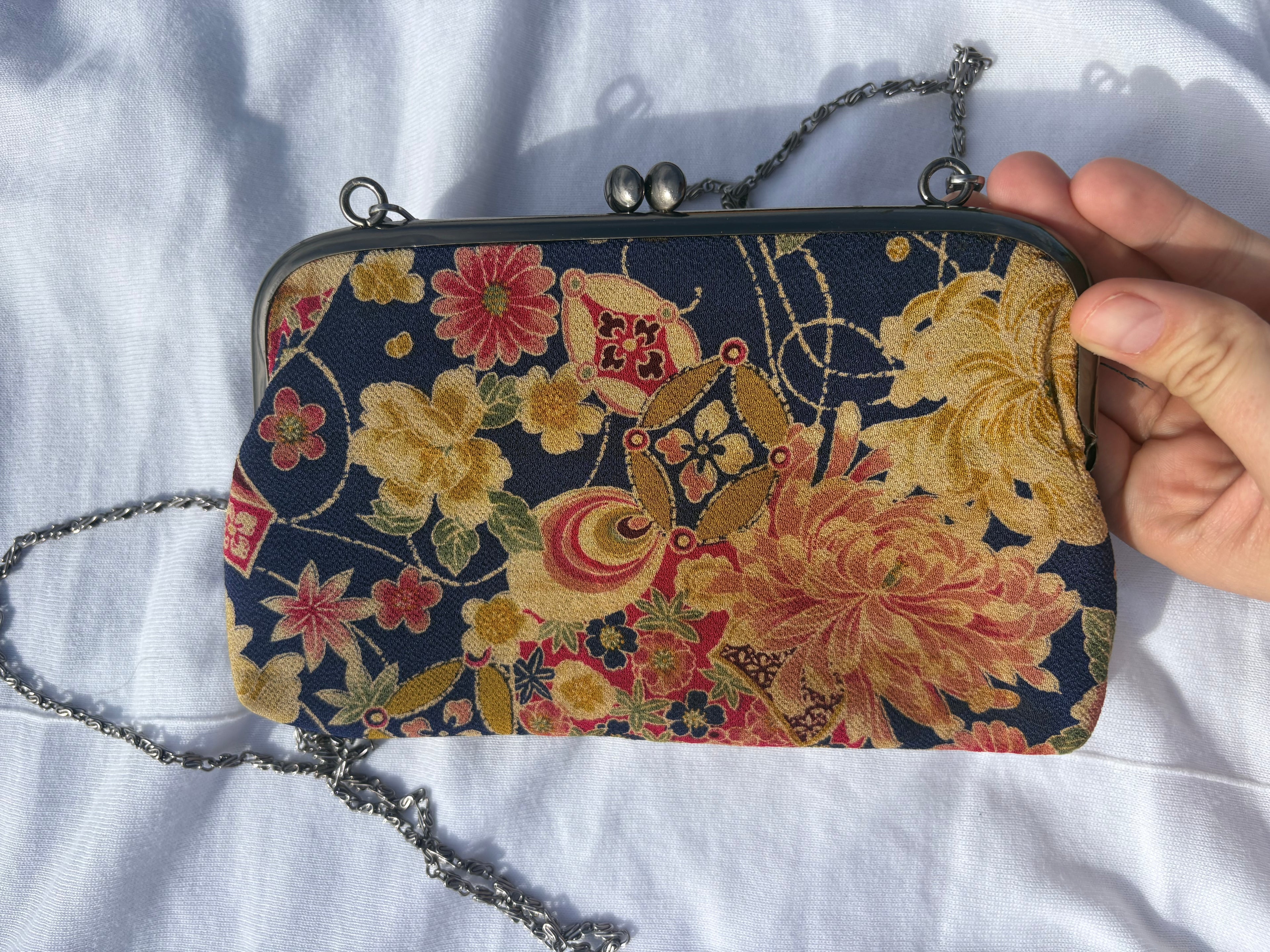 Clutch con motivos florales y cadena