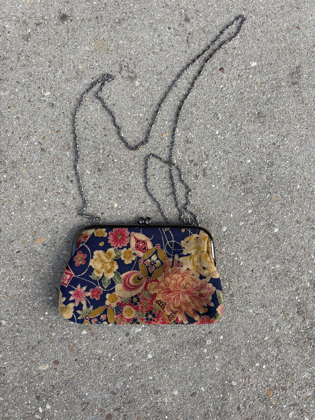 Clutch con motivos florales y cadena