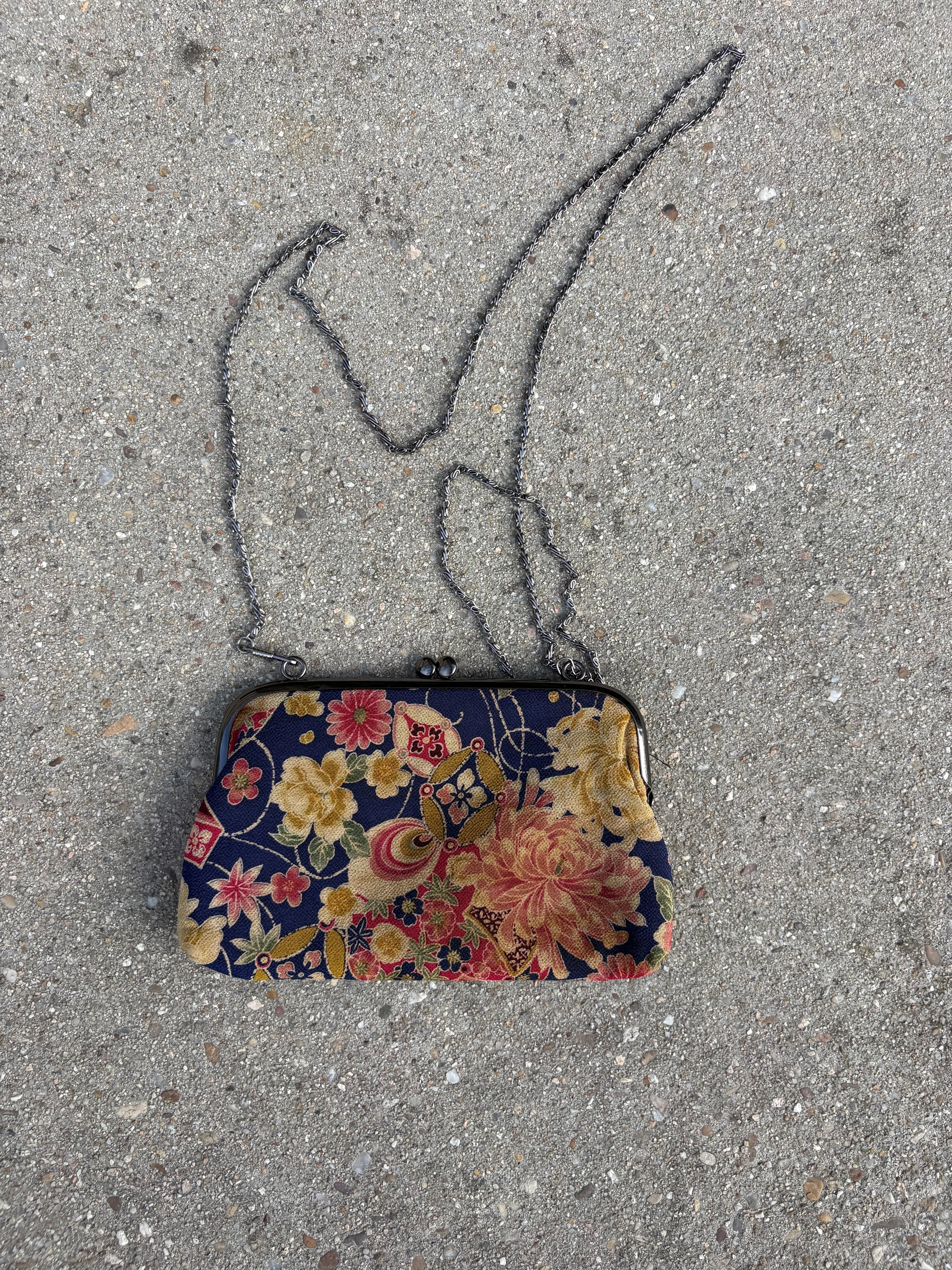 Clutch con motivos florales y cadena